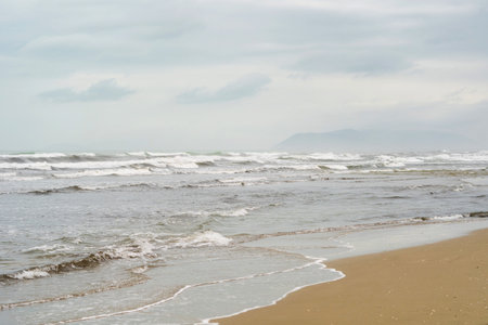 Panorama of beautiful white sand beach and blue water in Italy. Holiday summer beach background. Wave of the sea on sand beachの写真素材