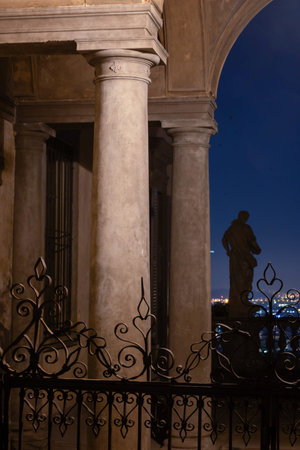 statue and ornate columns in historic building illuminated at nightの写真素材