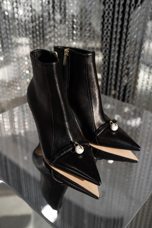 Milan, Italy - February, 25, 2023: Jimmy Choo shoes on podium showcase, woman accessories in the...