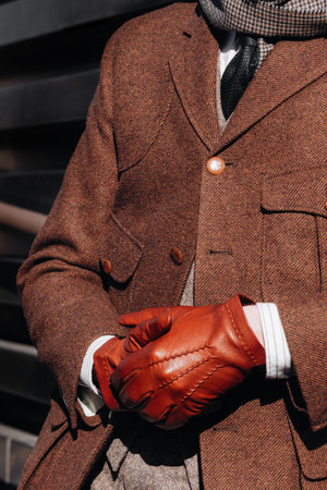 Florence, Italy - January, 12, 2021: Stylish ensemble featuring classic tweed jacket paired with striking red leather gloves. The sharp details and rich texturesのeditorial素材