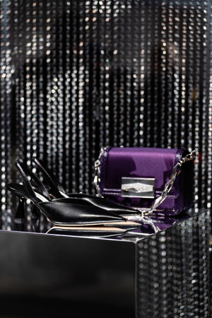 Milan, Italy - February, 25, 2023: Jimmy Choo bag and high heels on podium showcase, woman...