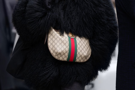 Florence, Italy - January, 10, 2024: woman wears Gucci bag, fashion blogger outfit details, street...