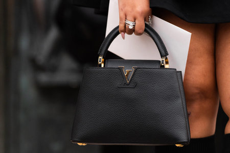 Milan, Italy - February, 25, 2024: woman wears Louis Vuitton bag, fashion blogger outfit details,...