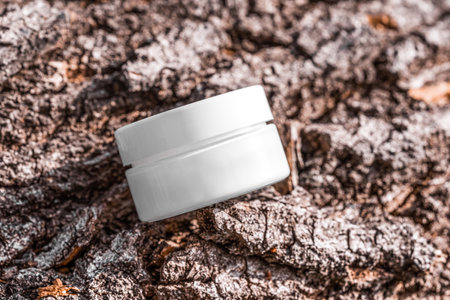 White cosmetic jar of firming cream on rugged tree bark surface display. Creme mock up, brand packaging on podium, skincare product with bakuchiol, sunscreen cosmetics branding mockupの写真素材