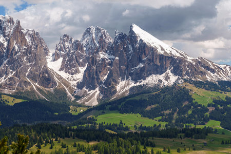 Majestic mountain range with snow-capped peaks and lush green near Valley of Funes at Dolomites,...