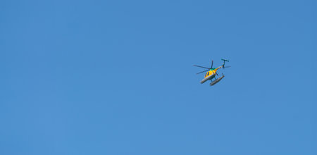 Helicopter flying in the blue sky. Concept of fast travel, holidays and business.の写真素材