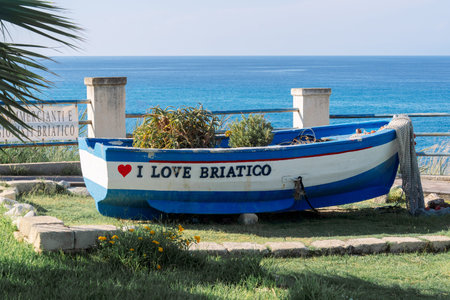 Boat with inscription Briatico shore on sea on sunny summer day