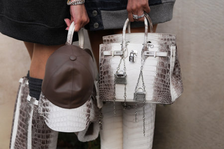 Paris, France - October, 4, 2025: Women wear Hermes Birkin white crocodile leather handbag with silver locks and chains and cap, street style fashion accessoriesのeditorial素材