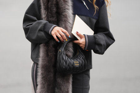Paris, France - October, 6, 2025: Woman wears Miu Miu Wander Matelasse Hobo black shoulder bag. Fashion outfit handbag detail, street style look accessoryのeditorial素材