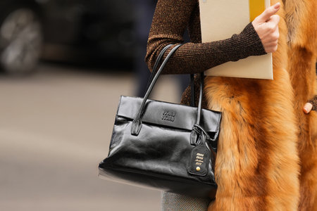 Paris, France - October, 6, 2025: Woman wears Miu Miu Solitaire black shoulder bag, street style outfit handbag detailsのeditorial素材