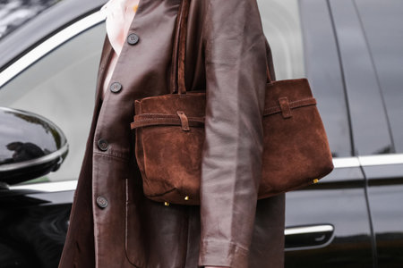 Paris, France - October, 6, 2025: Woman wears brown Manu Atelier suede shoulder bag. Fashion outfit handbag detail, street style look accessoryのeditorial素材