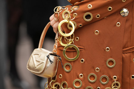 Paris, France - October, 6, 2025: Woman carries Diesel golden shoulder bag. Fashion outfit handbag detail, street style look accessoryのeditorial素材