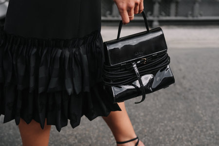 Milan, Italy - September, 25, 2025: woman wears Moschino Tie Me bag. Fashion outfit handbag details,...