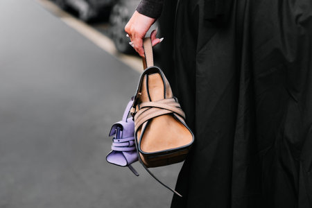 Milan, Italy - September, 25, 2025: woman wears Moschino Tie Me bag. Fashion outfit handbag details,...