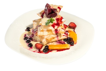 Delicious cake with berries and syrup isolated on whiteの写真素材