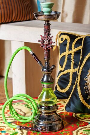 Beautiful green hookah standing on a table in the eastern interiorの写真素材