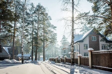 beautiful snowy street in winter village with treesの写真素材