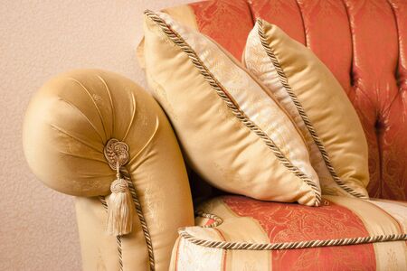 Beautiful sofa with pillows on a background of a wallの写真素材