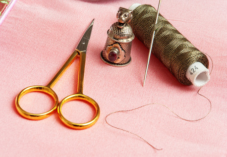 Thread with a needle on a pink backgroundの写真素材