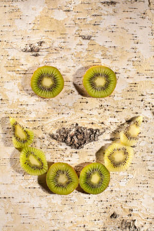Kiwi slices are laid out in a smile on grungy backgroundの写真素材