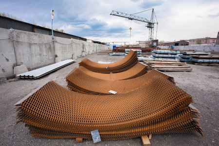 Crane and stack of steel grid at construction site