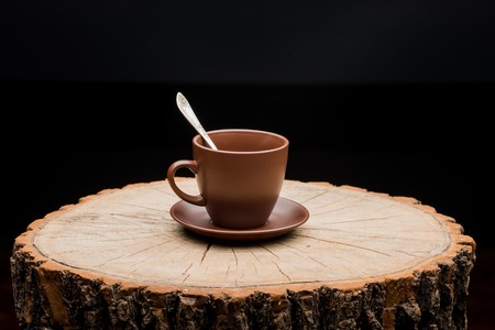 Cup on a stump on a black backgroundの写真素材