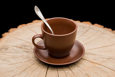 Cup on a stump on a black backgroundの写真素材