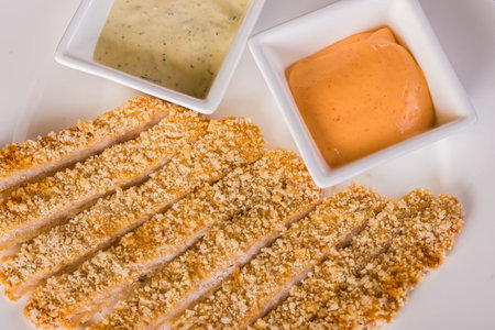 Breaded fish fillets with sauces on the tableの写真素材