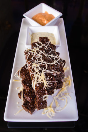 Pieces of toasted bread with cheese and sauces