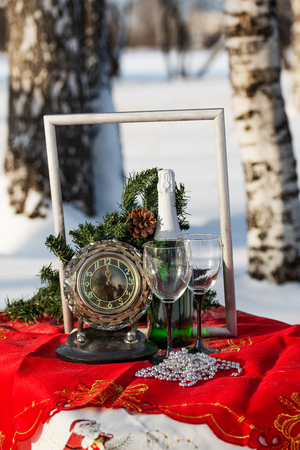 Champagne, glasses, watch and New Year's decorations  on the table in a forestの写真素材
