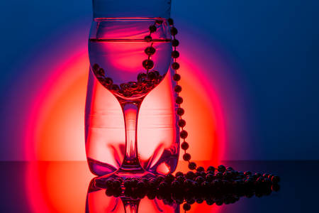 water glass with reflection on blue and orange backgroundの写真素材