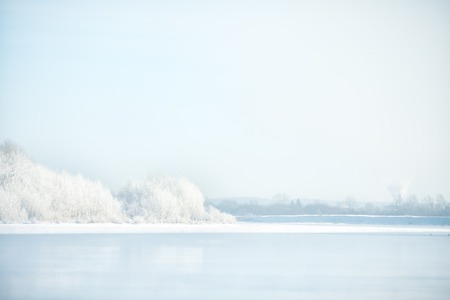 winter landscape with frozen river and trees in hoarfrostの写真素材