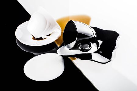 black and white coffee cups with plates on white and black backgroundの写真素材