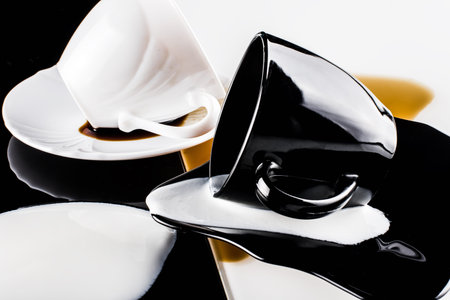 black and white coffee cups with plates on white and black backgroundの写真素材