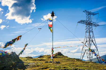 View of power plant and construction with colorful flags on the top of mountainの写真素材