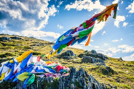 Construction with colorful flags against blue cloudy sky on the top of mountainの写真素材