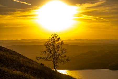 Beautiful landscape with hills and wide river at sunset