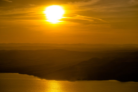 Beautiful landscape with hills and wide river at sunsetの写真素材
