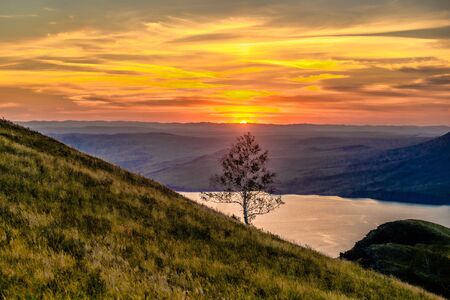 Beautiful landscape with hills and wide river at sunsetの写真素材