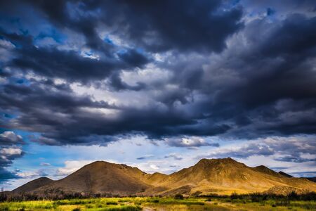 Stormy clouds in a blue sky over the mountainsの写真素材