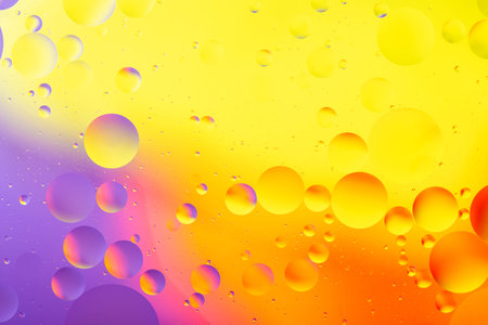 bright oily drops in water with colorful background, close-up