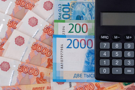 Black calculator on russian rubles banknotes background.