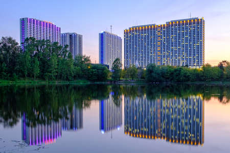 Moscow - August 17, 2018: Landscape with evening view on complex buildings of city hotel "Izmailovo" with reflections in water.のeditorial素材