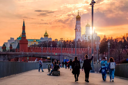 Moscow - 28 april 2021: City evening landscape. People walk along embankment of Moscow river. Towers...