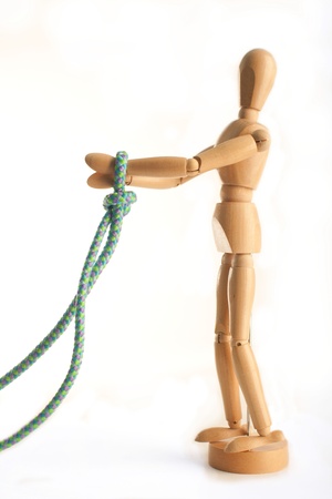 Wooden Artist's Model posed with hands tied with a blue rope set on a white background.  Illustrating the saying 'My Hands are Tied.'の写真素材