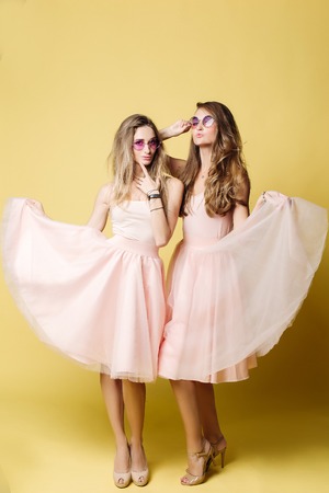 Two attractive girlfriends dancing, posing together.の写真素材