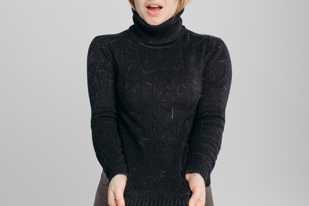 Shocked woman showing her dirty black sweater at camera.の写真素材