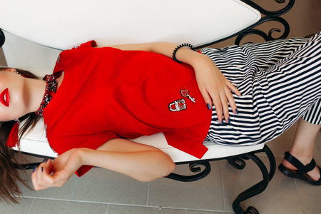 Pretty girl wearing trendy clothes and red lips, lying and relaxing.の写真素材