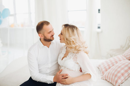Beautiful couple embracing stomach and touching face to face.の写真素材