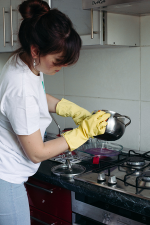 Close up of woman hands in gloves wahing pan.の写真素材